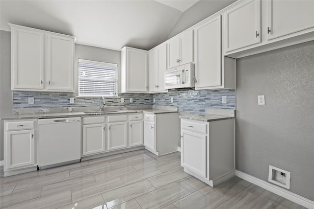 kitchen featuring lofted ceiling, sink, white appliances, white cabinetry, and light stone counters