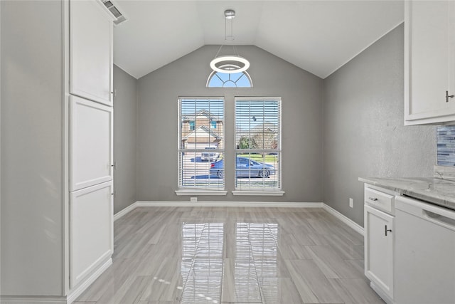 unfurnished dining area with vaulted ceiling