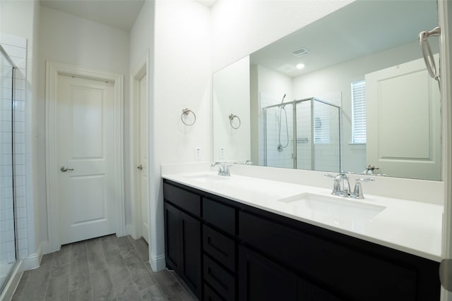 bathroom featuring vanity, wood-type flooring, and a shower with door