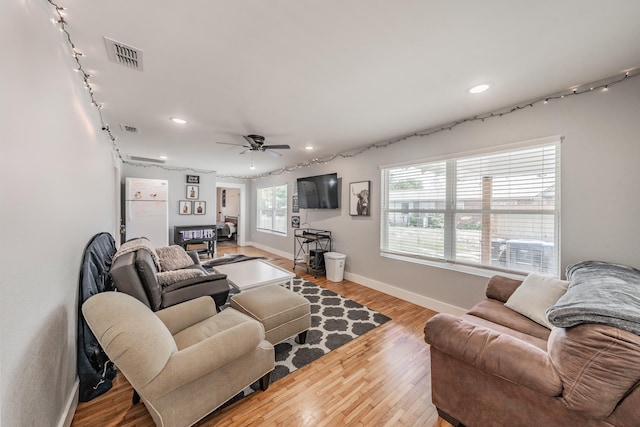 living room with ceiling fan and light hardwood / wood-style flooring