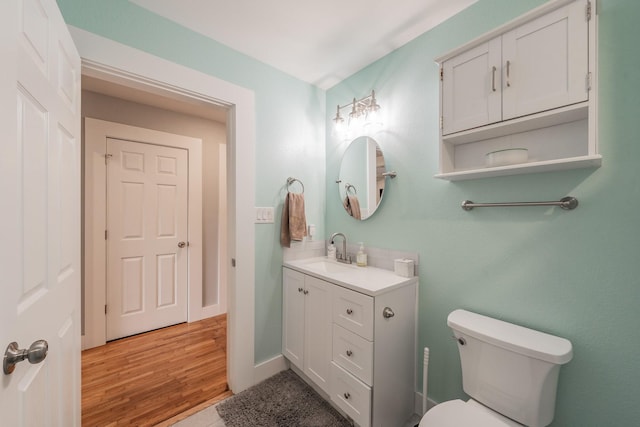 bathroom featuring toilet, wood-type flooring, and vanity