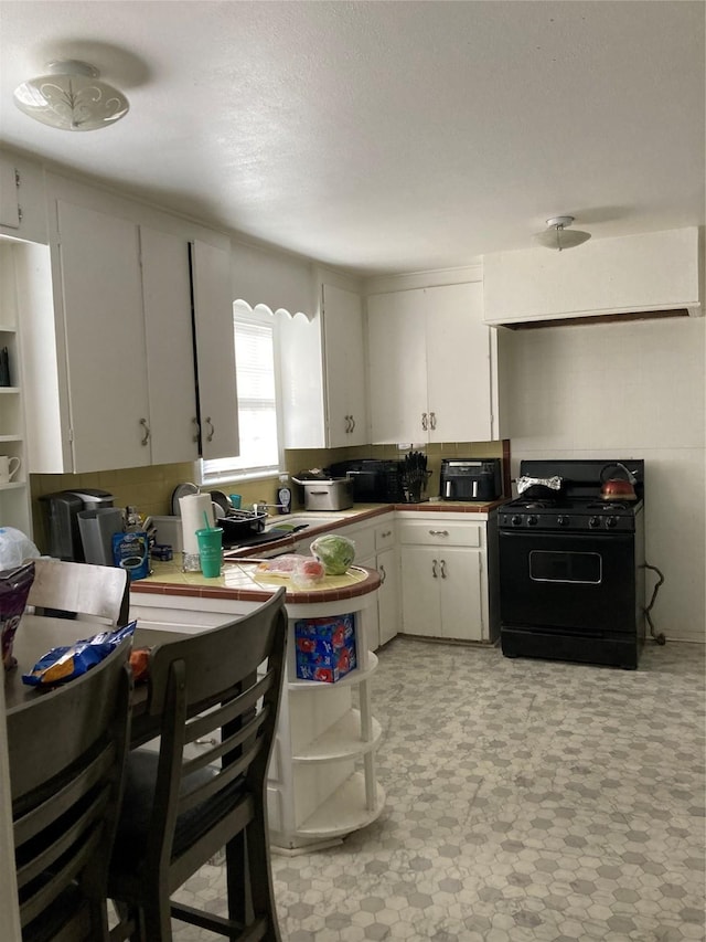 kitchen with white cabinetry and black range with gas cooktop