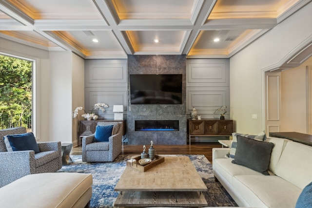 living room featuring a fireplace, beamed ceiling, coffered ceiling, and ornamental molding