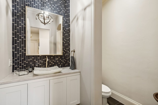 bathroom with backsplash, toilet, and vanity