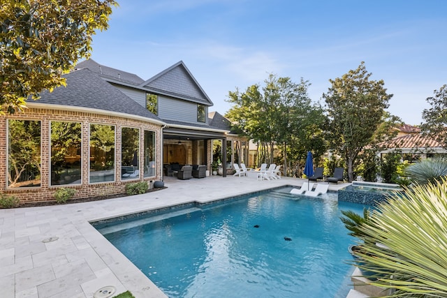 view of swimming pool featuring an in ground hot tub and a patio