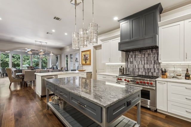 kitchen with premium range hood, hanging light fixtures, a center island, and stainless steel appliances