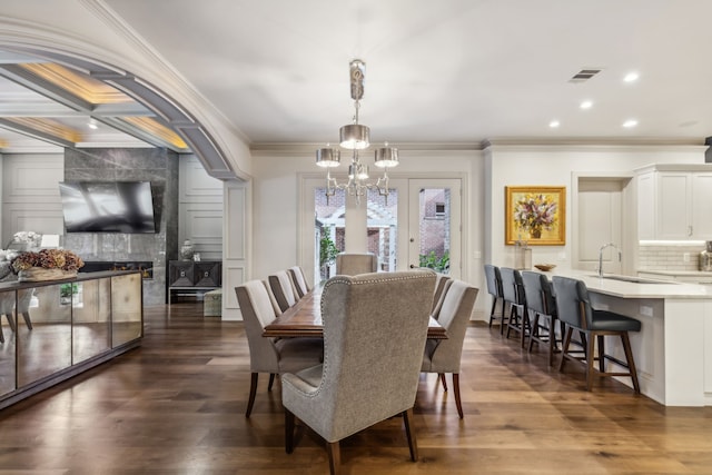 dining room with french doors, sink, dark hardwood / wood-style floors, crown molding, and coffered ceiling