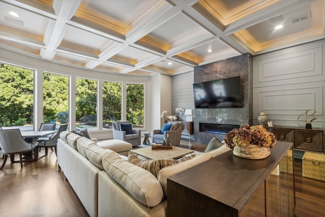 living room featuring beam ceiling, a premium fireplace, coffered ceiling, and ornamental molding