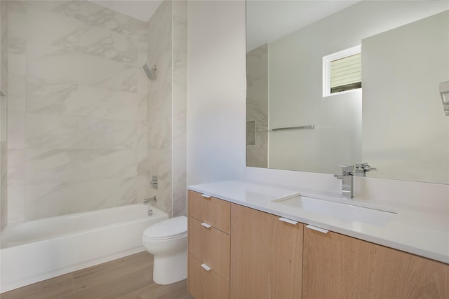 full bathroom with toilet, tiled shower / bath combo, wood-type flooring, and vanity