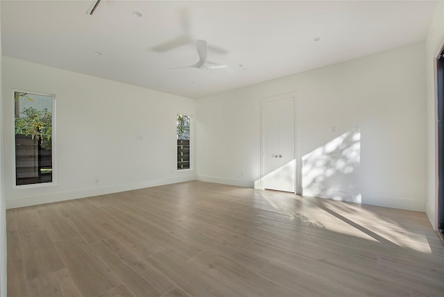 unfurnished room featuring ceiling fan, light wood-type flooring, and plenty of natural light