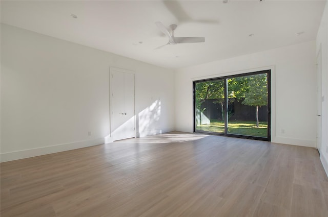 empty room with ceiling fan and light hardwood / wood-style floors