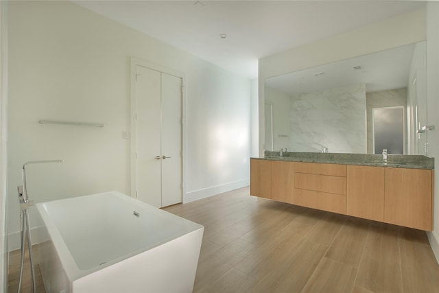 bathroom featuring hardwood / wood-style flooring, vanity, and shower with separate bathtub