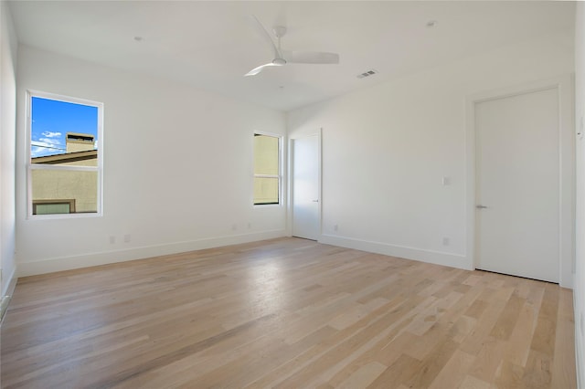 empty room with ceiling fan and light hardwood / wood-style floors