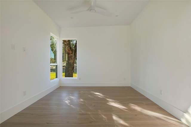 spare room with ceiling fan, a healthy amount of sunlight, and wood-type flooring