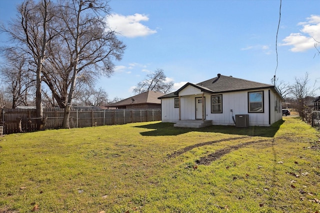 rear view of property with a lawn and cooling unit