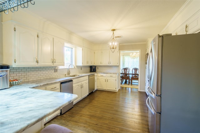 kitchen featuring stainless steel appliances, backsplash, decorative light fixtures, a chandelier, and white cabinets