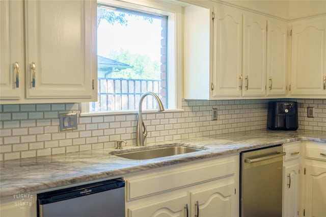 kitchen featuring stainless steel dishwasher, white cabinets, and sink