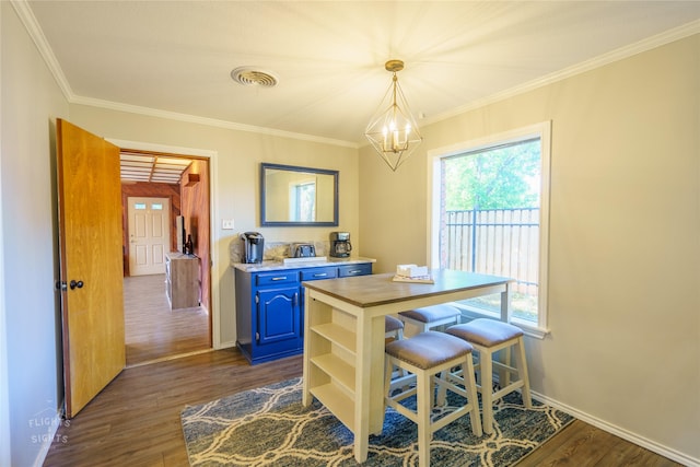 dining area featuring dark wood-type flooring, an inviting chandelier, crown molding, and plenty of natural light