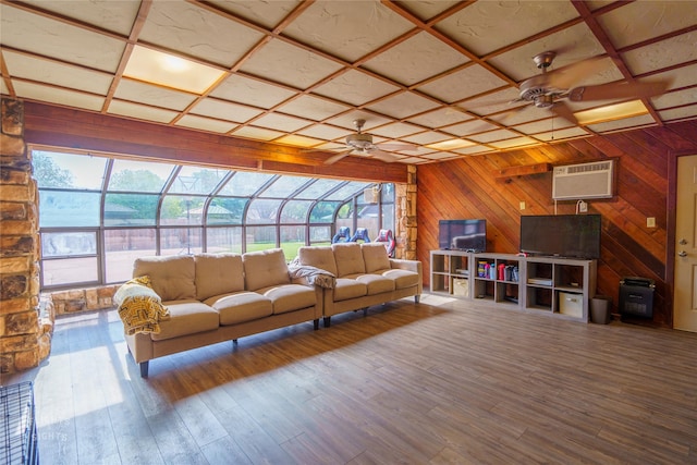 living room with a wall unit AC, ceiling fan, wood-type flooring, and coffered ceiling