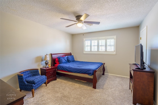 carpeted bedroom with ceiling fan and a textured ceiling