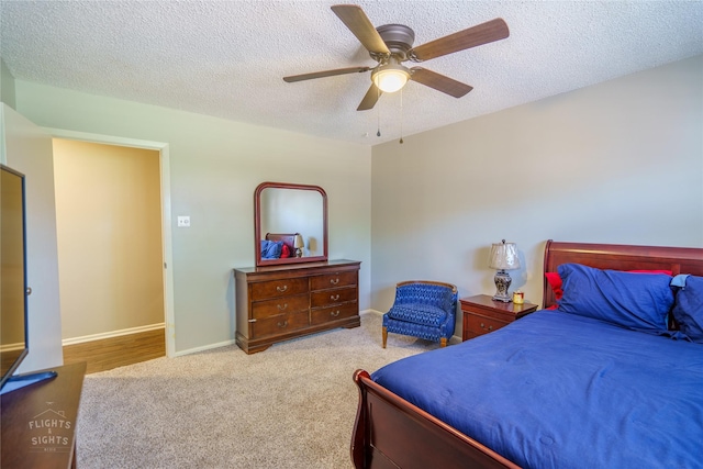 carpeted bedroom featuring a textured ceiling and ceiling fan