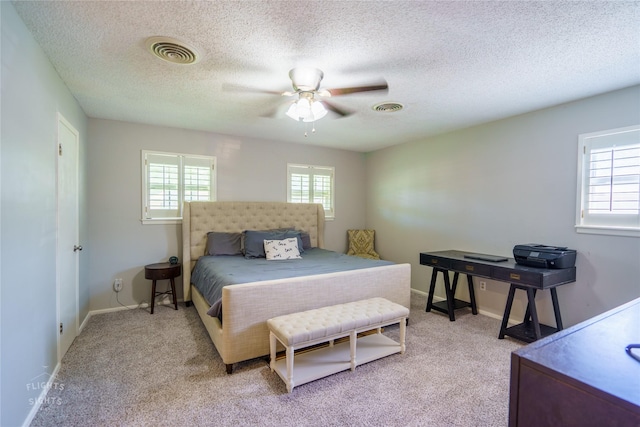 carpeted bedroom with a textured ceiling and ceiling fan