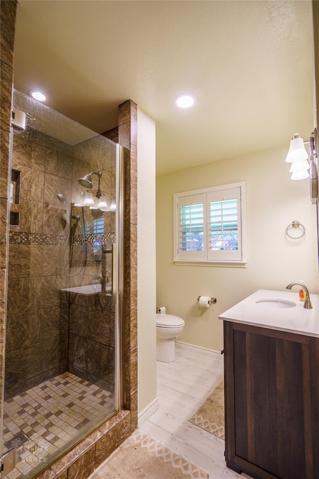 bathroom with toilet, walk in shower, hardwood / wood-style floors, and vanity