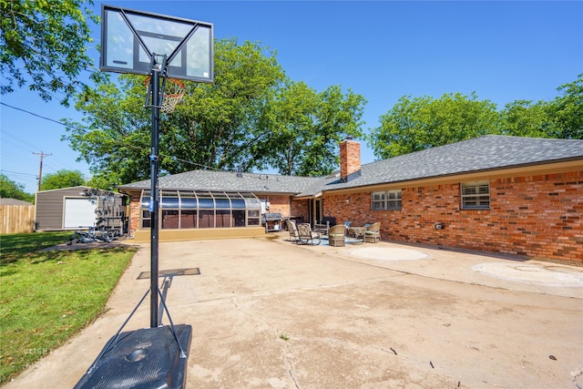 view of patio featuring a garage, a sunroom, and an outbuilding