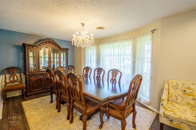 dining space with a notable chandelier, dark hardwood / wood-style flooring, and a textured ceiling