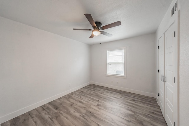 unfurnished bedroom featuring ceiling fan, a textured ceiling, and hardwood / wood-style floors