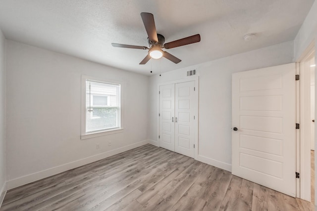 unfurnished bedroom with ceiling fan, a closet, and light hardwood / wood-style flooring