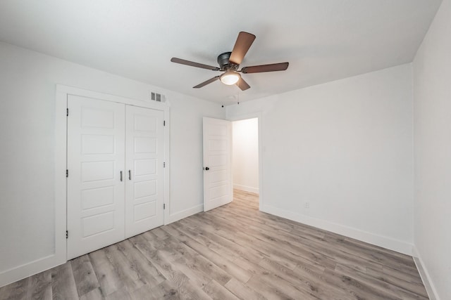 unfurnished bedroom with ceiling fan, a closet, and light hardwood / wood-style flooring