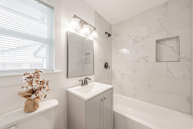 full bathroom with toilet, vanity, and tiled shower / bath