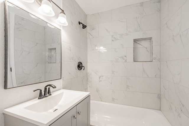 bathroom featuring tiled shower / bath and vanity