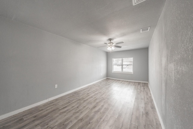 empty room featuring ceiling fan, a textured ceiling, and light wood-type flooring