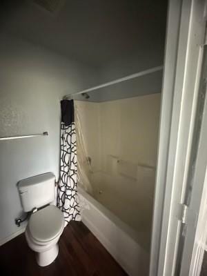 bathroom featuring toilet, shower / bathing tub combination, and hardwood / wood-style flooring