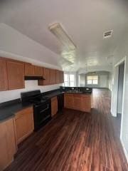 kitchen with dark hardwood / wood-style flooring and black gas range oven