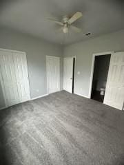 unfurnished bedroom with ceiling fan and dark carpet