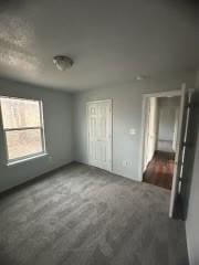 unfurnished bedroom with dark carpet