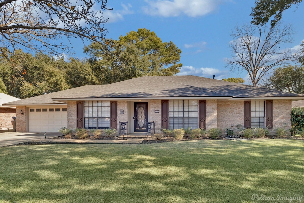 ranch-style house with a garage and a front yard