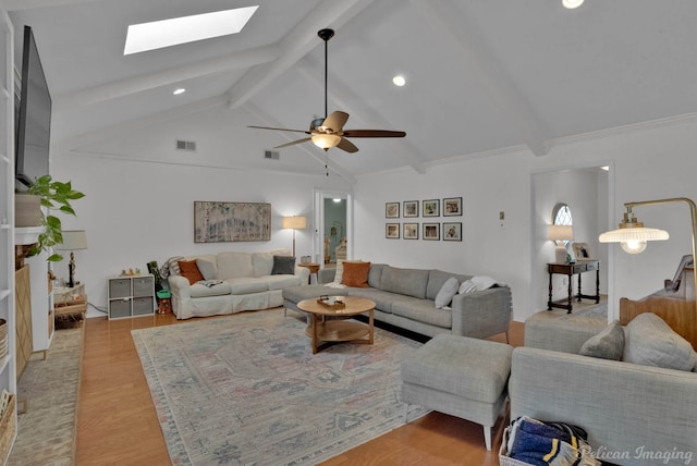 living room featuring ceiling fan, light hardwood / wood-style floors, and lofted ceiling with skylight