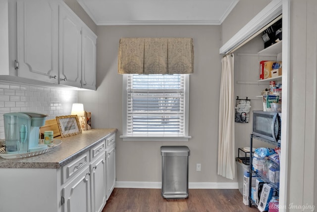 kitchen featuring dark wood-type flooring, ornamental molding, decorative backsplash, and white cabinets