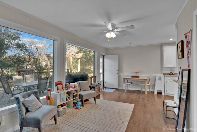 interior space with ceiling fan, ornamental molding, and light hardwood / wood-style flooring