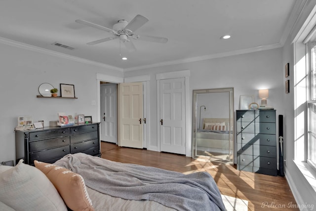 bedroom with ceiling fan, dark hardwood / wood-style flooring, crown molding, and ensuite bath