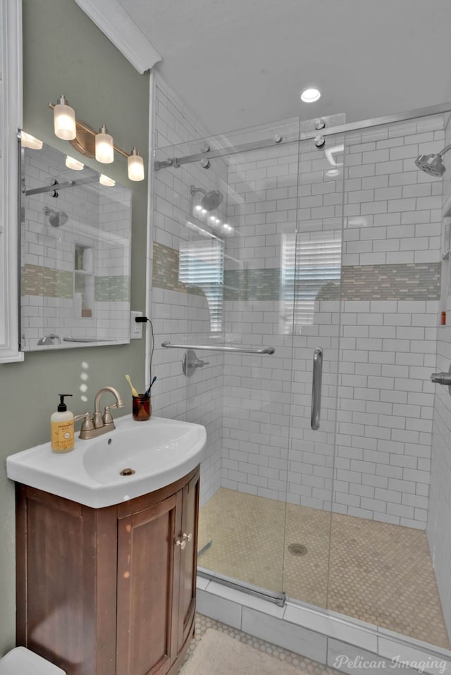 bathroom with an enclosed shower, vanity, tile patterned flooring, and crown molding