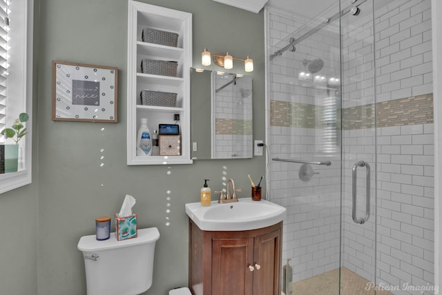 bathroom with toilet, an enclosed shower, and vanity