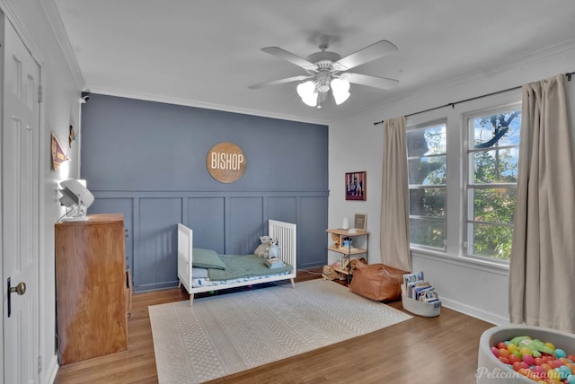 bedroom with ceiling fan, crown molding, and hardwood / wood-style floors