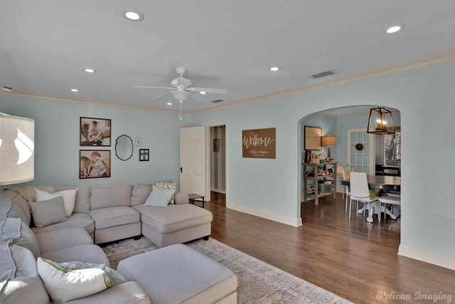 living room with ceiling fan, dark wood-type flooring, and ornamental molding