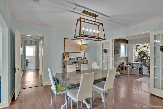 dining area featuring french doors, crown molding, and hardwood / wood-style floors