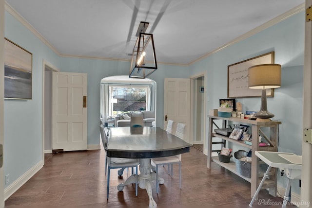 dining space featuring dark wood-type flooring and crown molding